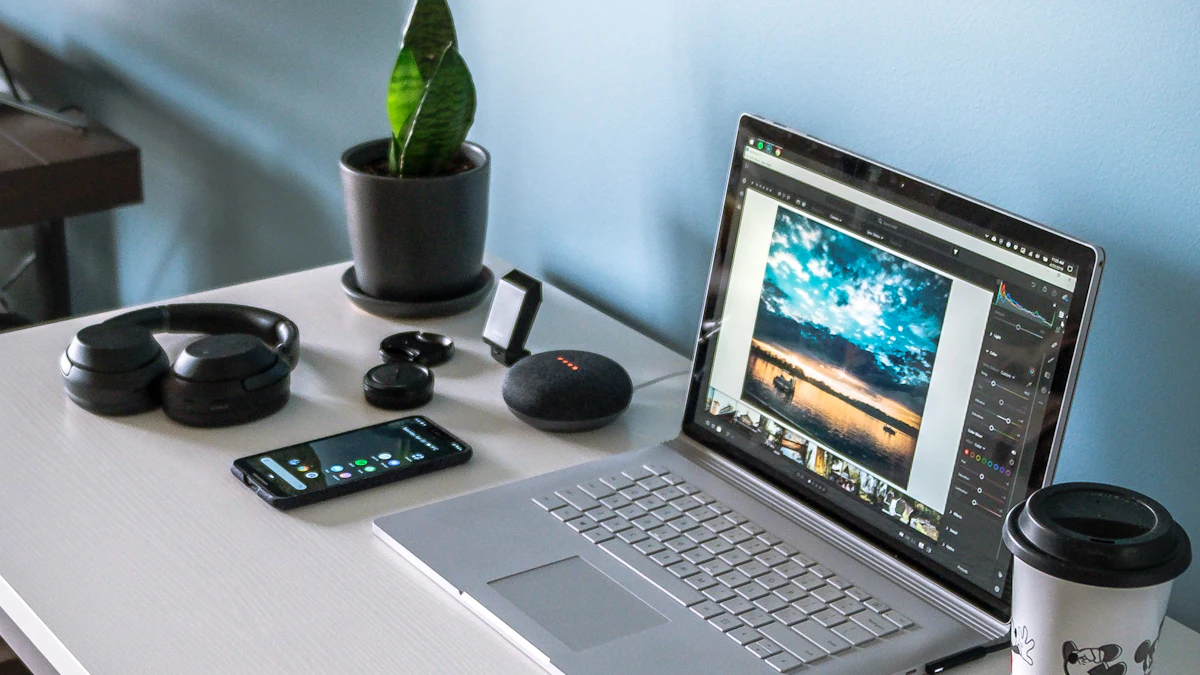 A laptop on a desk beside a plant and a coffee cup.